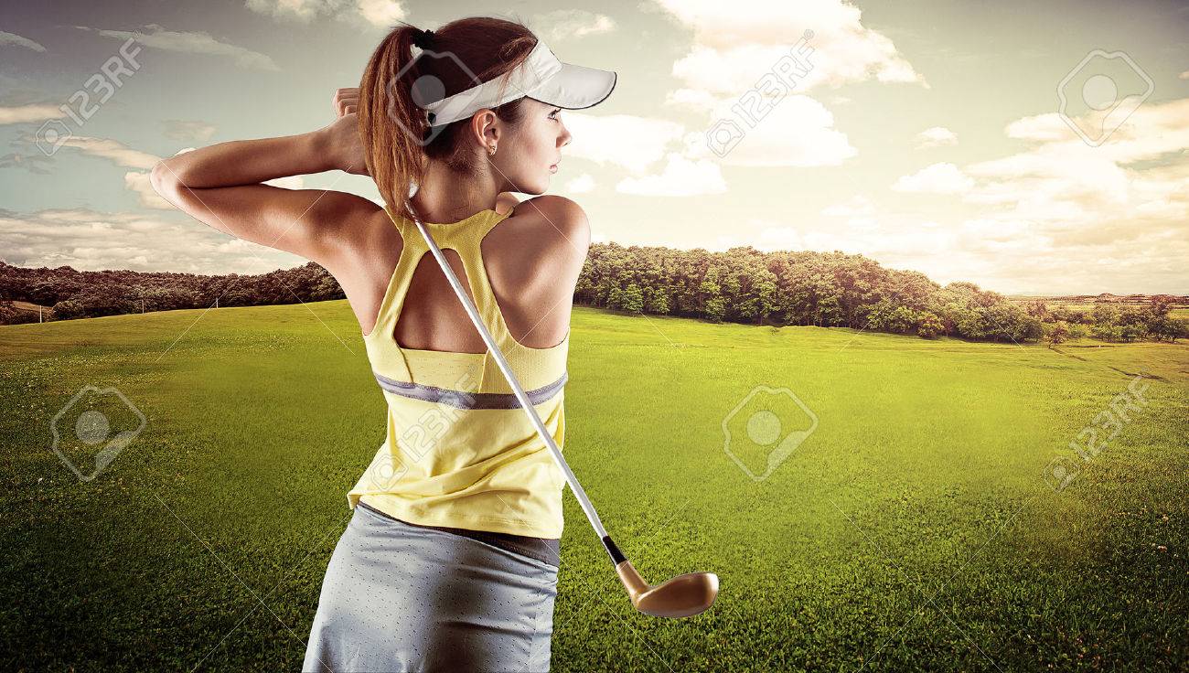 Young female in sportswear playing golf on green field. Active fresh Caucasian woman swinging with golf club. - 39668294 Young female in sportswear playing golf on green field. Active fresh Caucasian woman swinging with golf club. - 39668294