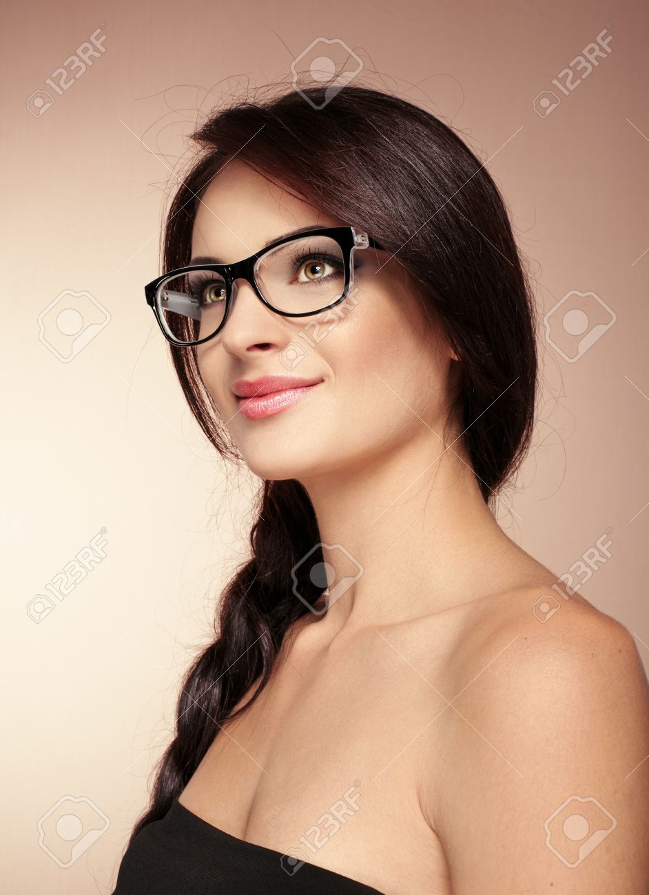 美容スタジオでポーズをとってメガネを着てエレガントな魅力的な女性の肖像画 華やかな髪型とメイクと若い素敵な白人女性 の写真素材 画像素材 Image