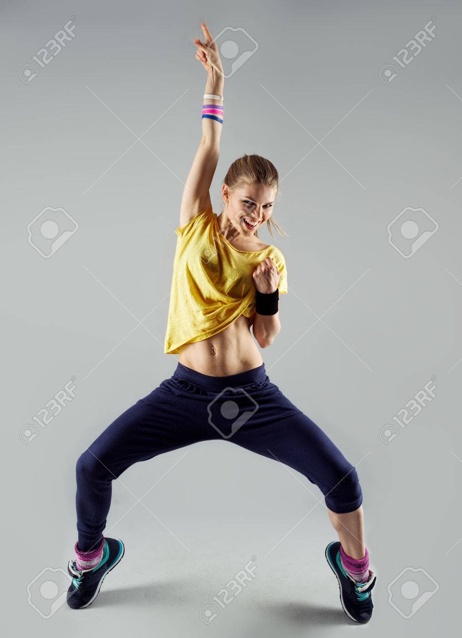 Happy girl working out dance standing with hand up. Dynamic woman fitness trainer dancing for fun. - 39330628 Happy girl working out dance standing with hand up. Dynamic woman fitness trainer dancing for fun. - 39330628