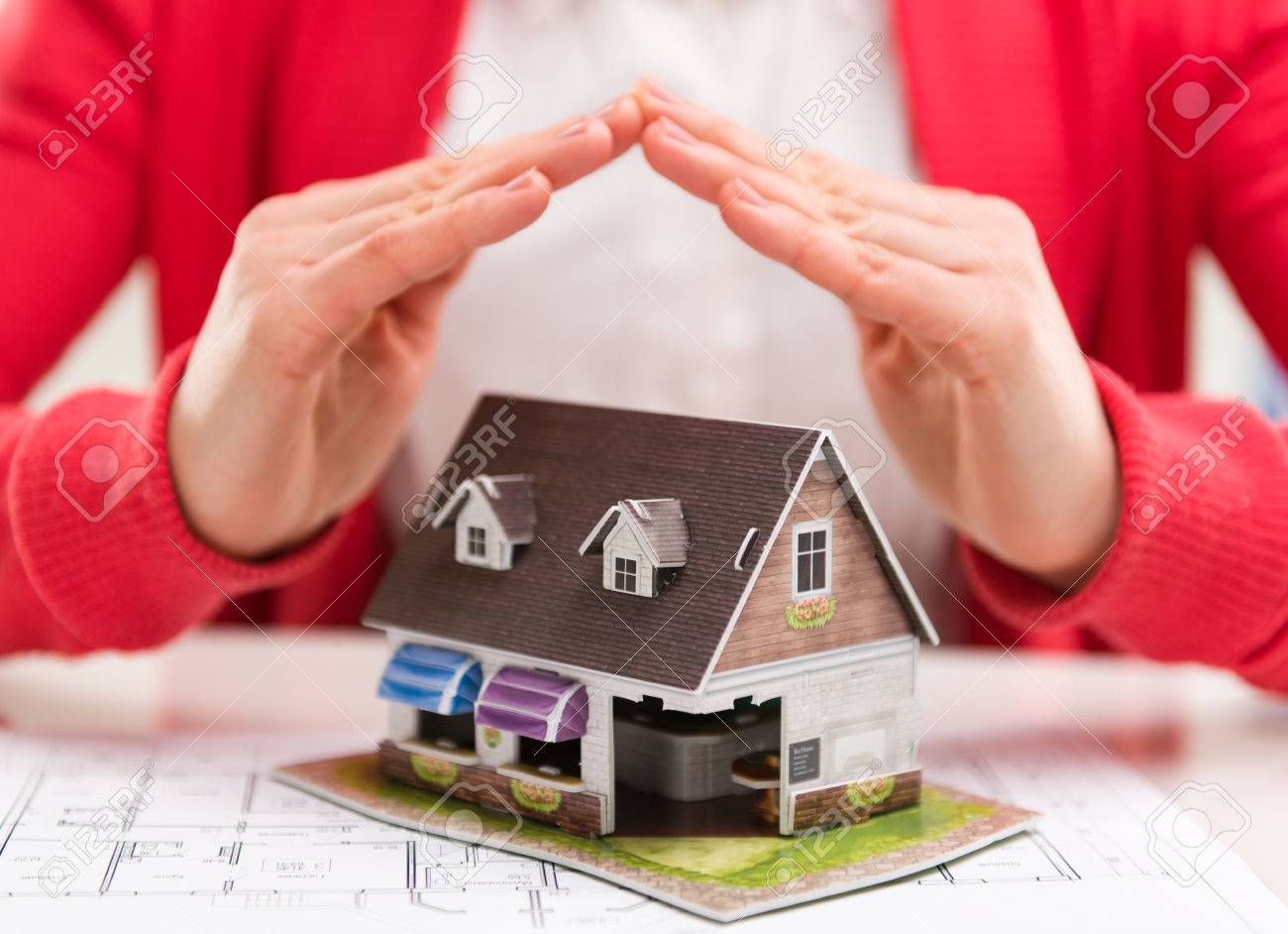 Close-up of mortgage agent hands with family house model in real estate agency. Concept of real estate loan agreement. Shallow depth of field. - 39619497 Close-up of mortgage agent hands with family house model in real estate agency. Concept of real estate loan agreement. Shallow depth of field. - 39619497