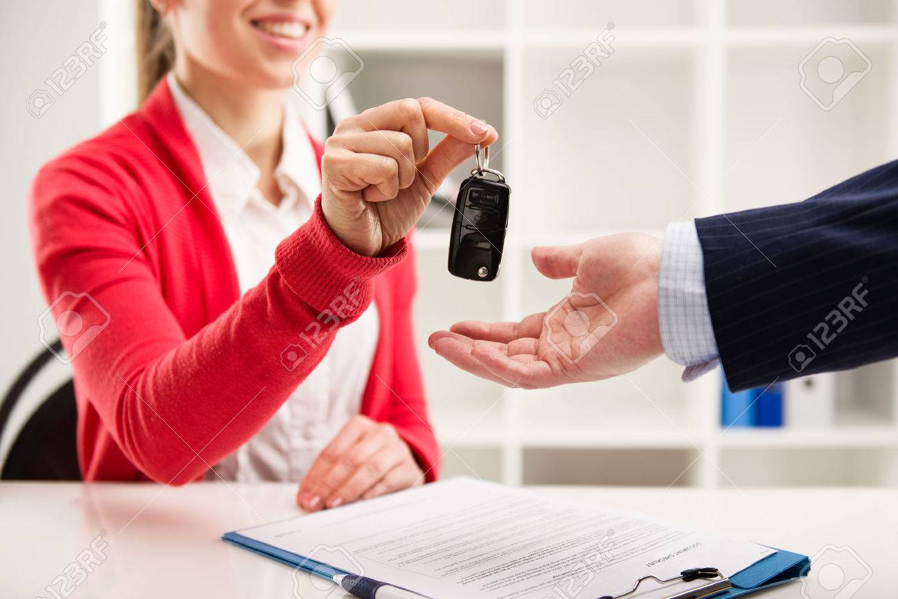 Female car agent giving key to male customer for test drive. Partnership and contract signing. - 39598925 Female car agent giving key to male customer for test drive. Partnership and contract signing. - 39598925