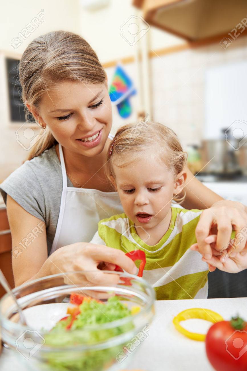 幸福 子供の頃 一体感 陽気な家族が台所のテーブルでベジタリアンの食事を調理します の写真素材 画像素材 Image