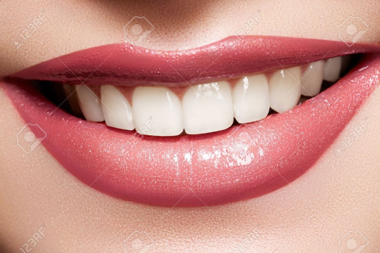 Close-up happy female smile with healthy white teeth, bright gloss lips make-up. Cosmetology, dental and beauty care - 11572500 Close-up happy female smile with healthy white teeth, bright gloss lips make-up. Cosmetology, dental and beauty care - 11572500