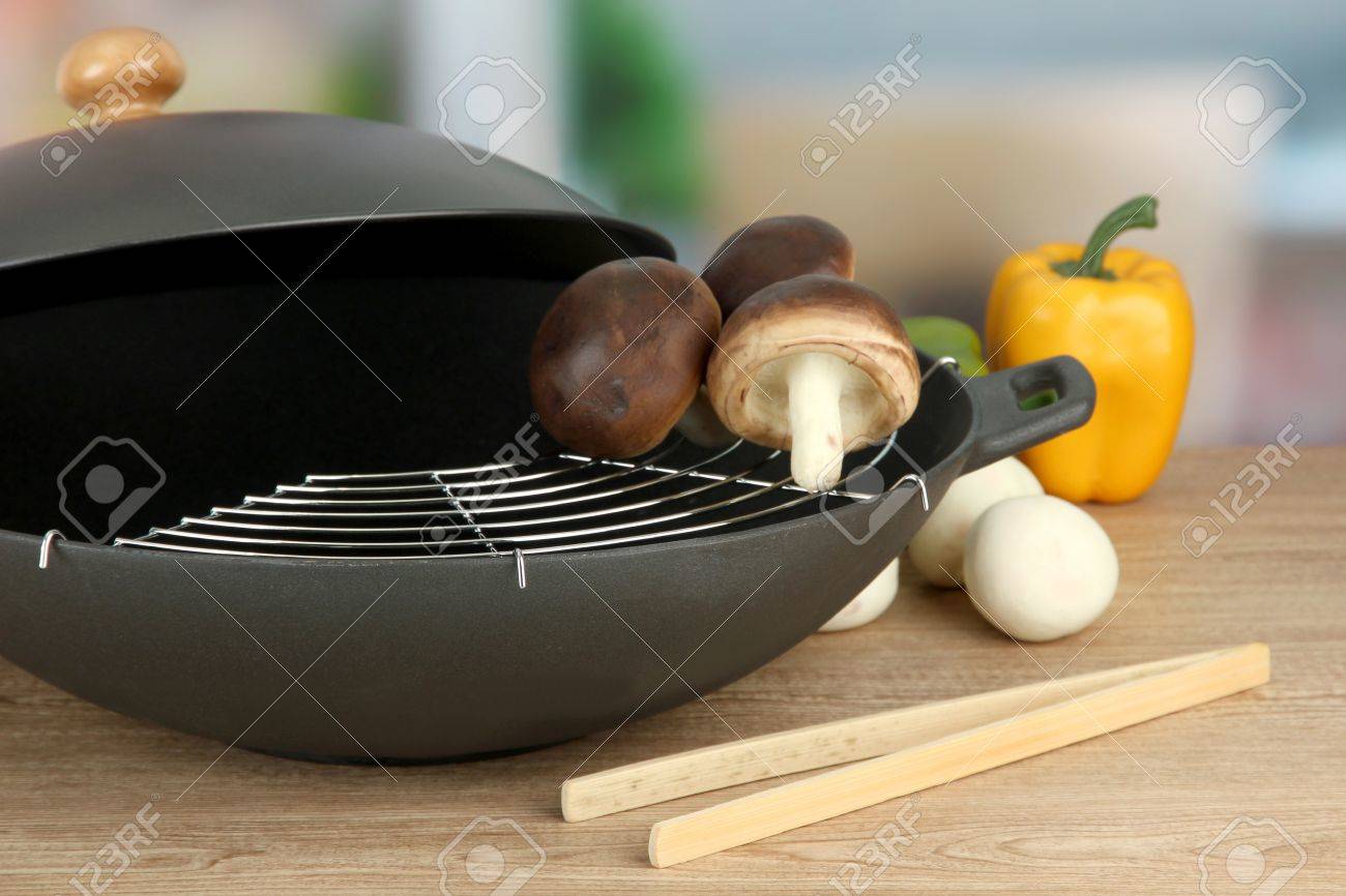 Kitchen Table Close Up black wok pan and vegetables on kitchen table, close up stock Kitchen Table Close Up black wok pan and vegetables on kitchen table, close up stock