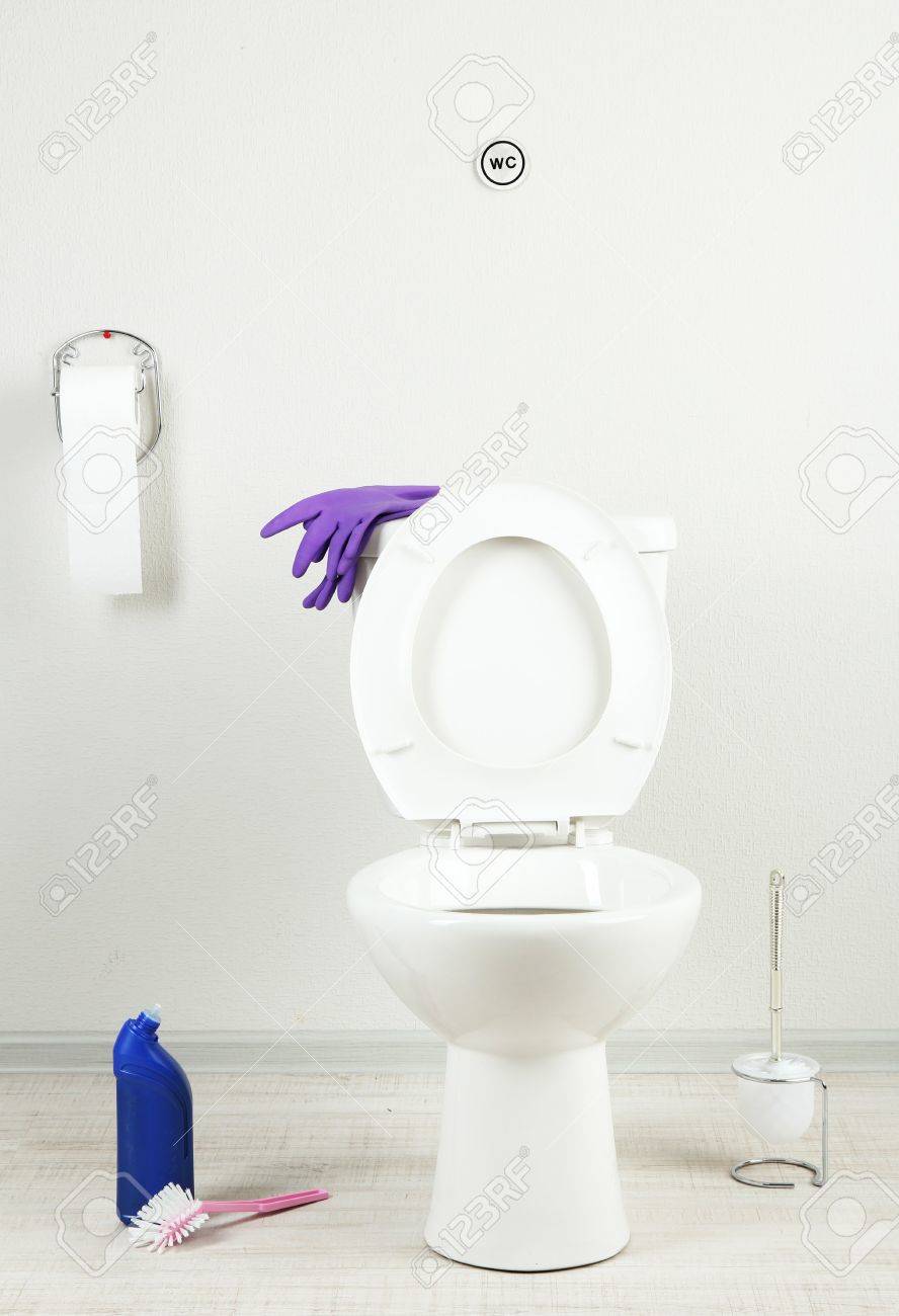 White Toilet Bowl And Cleaner Bottle In A Bathroom Stock Photo