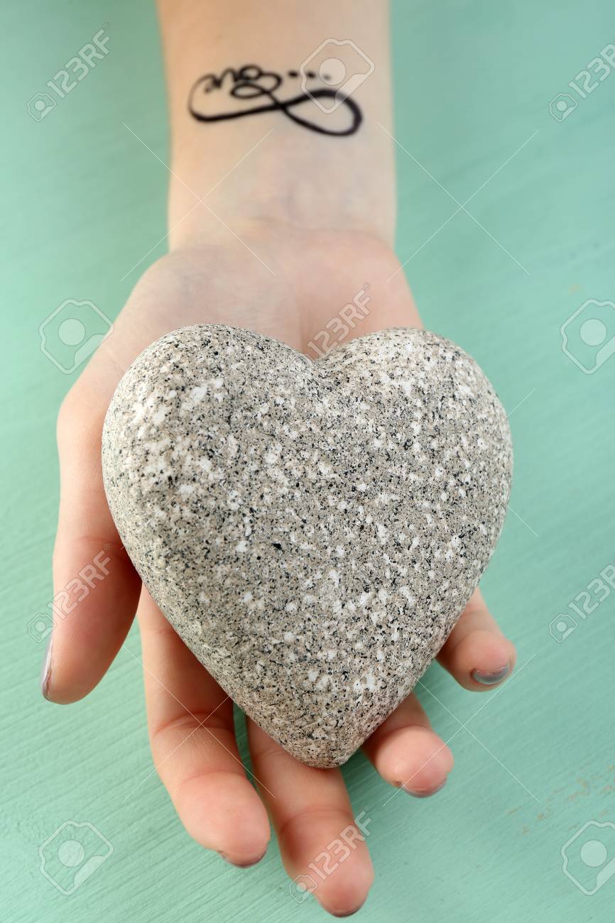 Femme Bras Avec Tatouage Tenant Coeur Décoratif Sur Fond De Bois