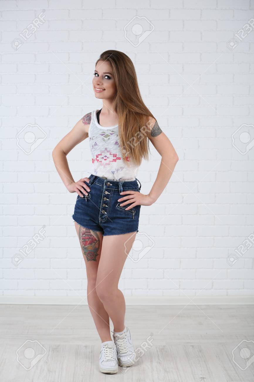 Beautiful Girl With Stylish Make Up And Tattooed Body On Light