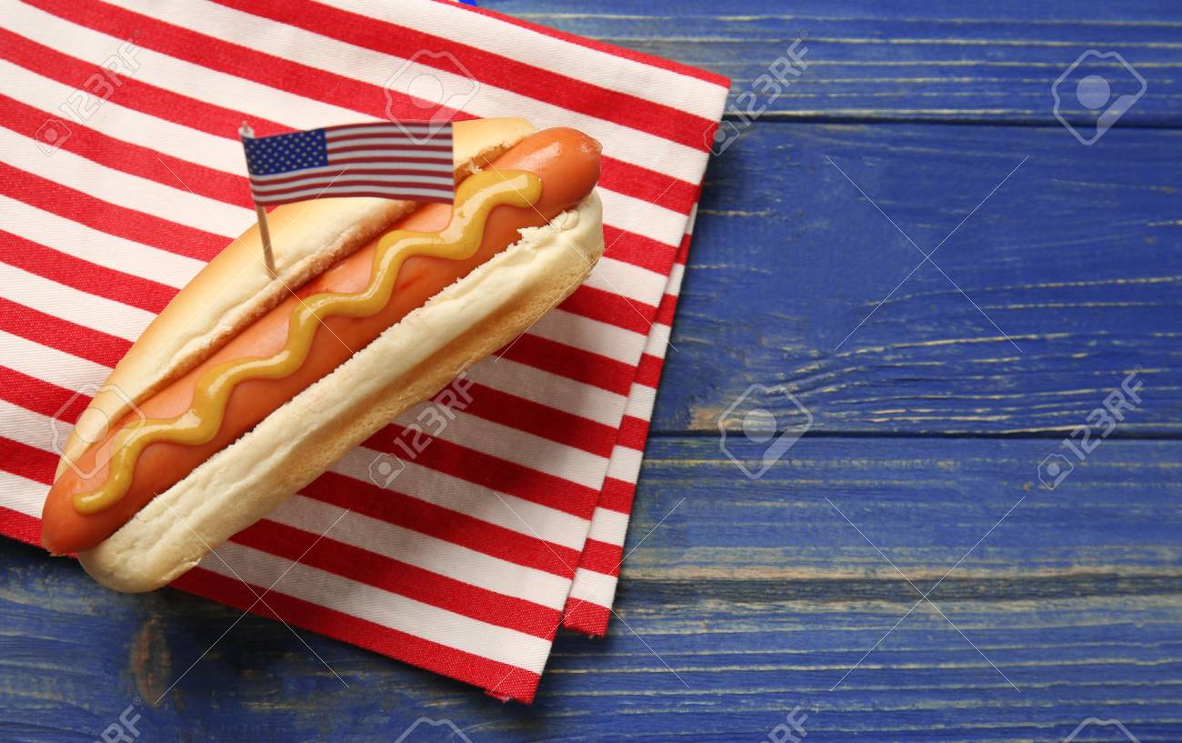 Hot dog with mustard and small USA flag on napkin - 107949125 Hot dog with mustard and small USA flag on napkin - 107949125