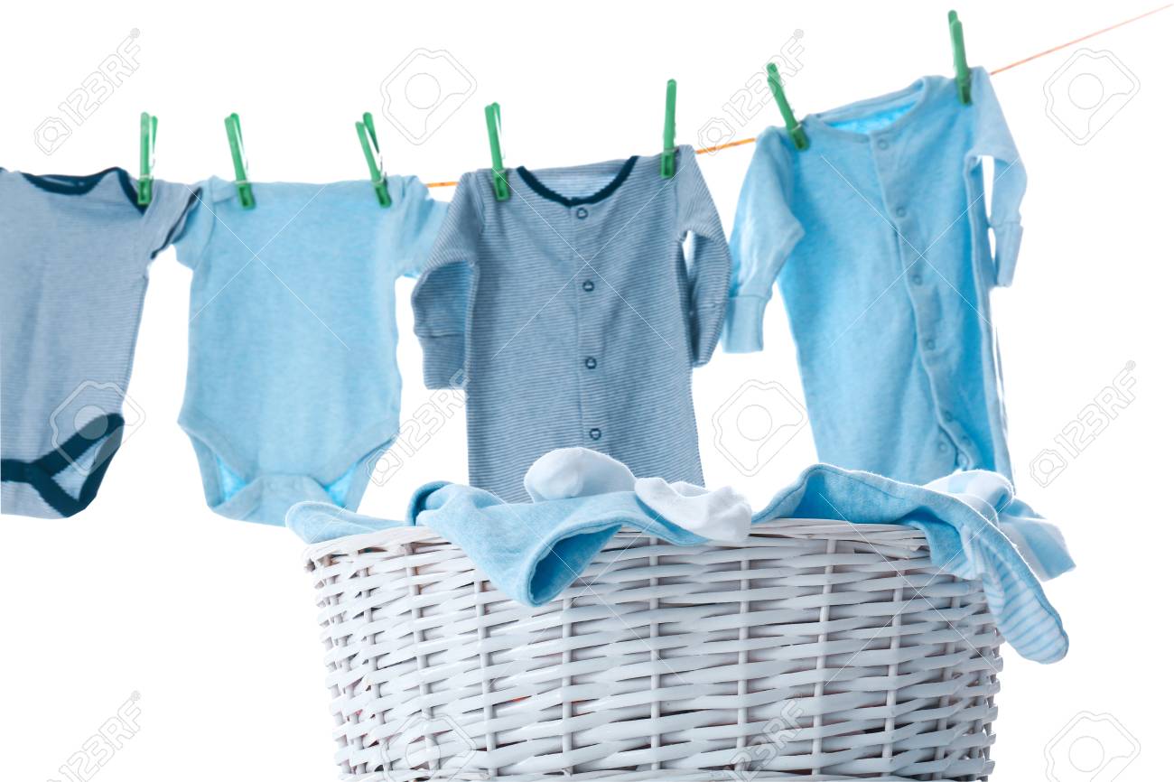 Children's clothes on washing line and laundry basket against white background - 112896364 Children's clothes on washing line and laundry basket against white background - 112896364