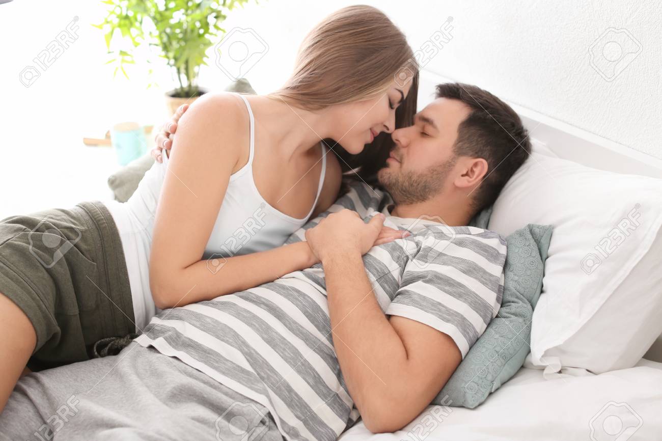 Morning Of Young Lovely Couple Lying On Bed At Home