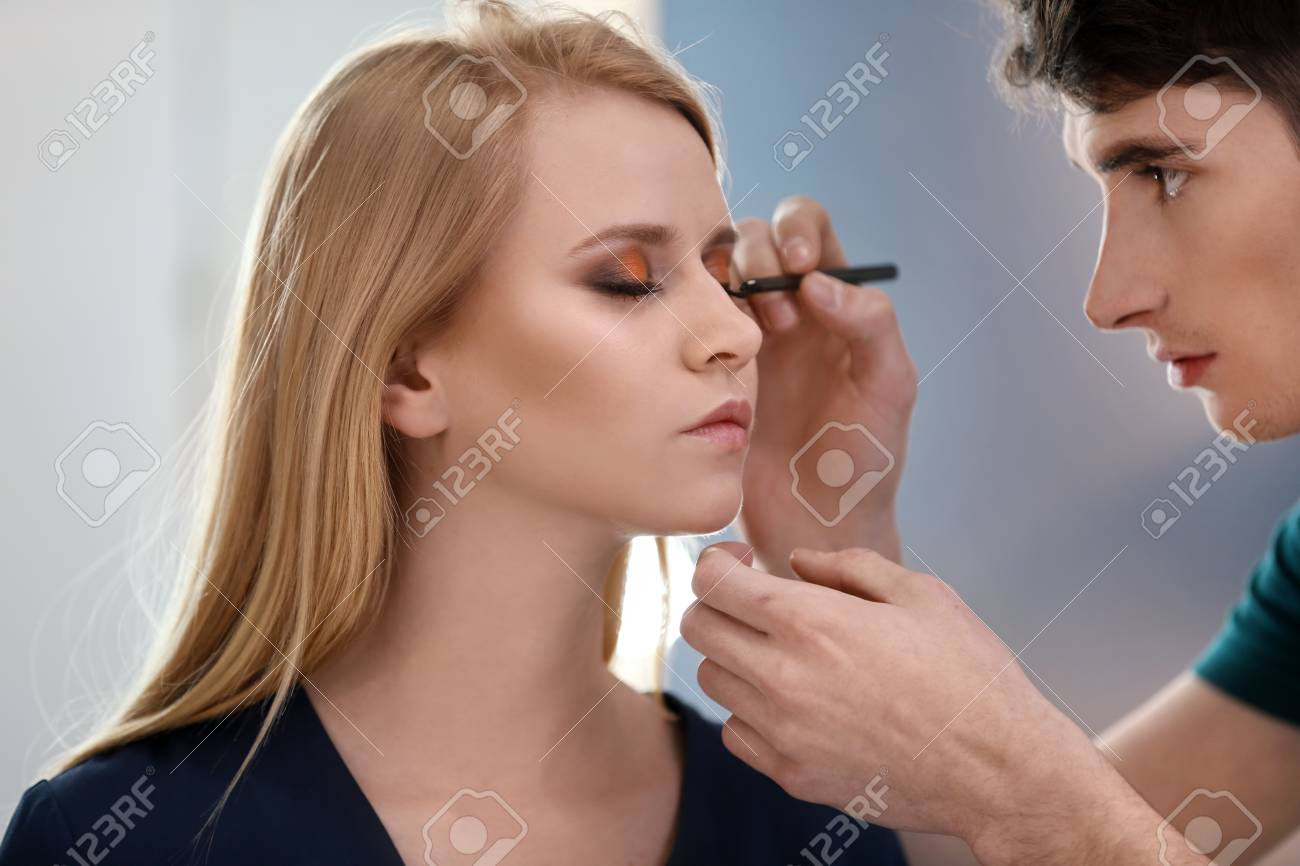 Professional Makeup Artist Working With Young Model In Salon