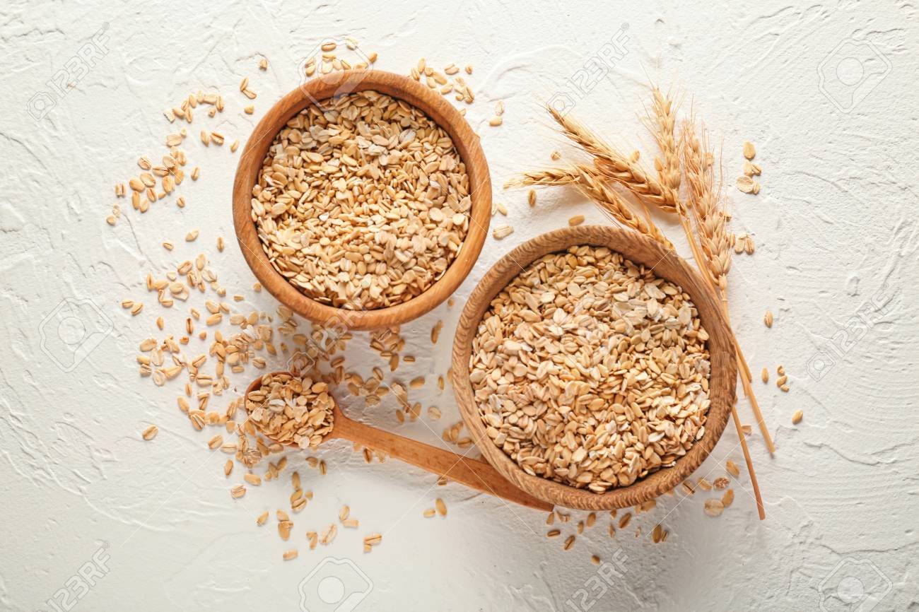 Bowls with raw oatmeal on light background - 113906190 Bowls with raw oatmeal on light background - 113906190