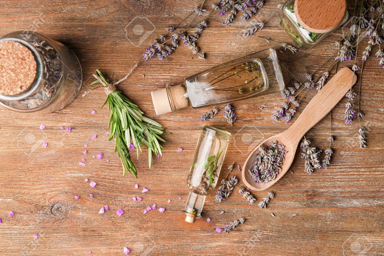 Bottles of essential oil with lavender and rosemary on wooden table - 114675925 Bottles of essential oil with lavender and rosemary on wooden table - 114675925