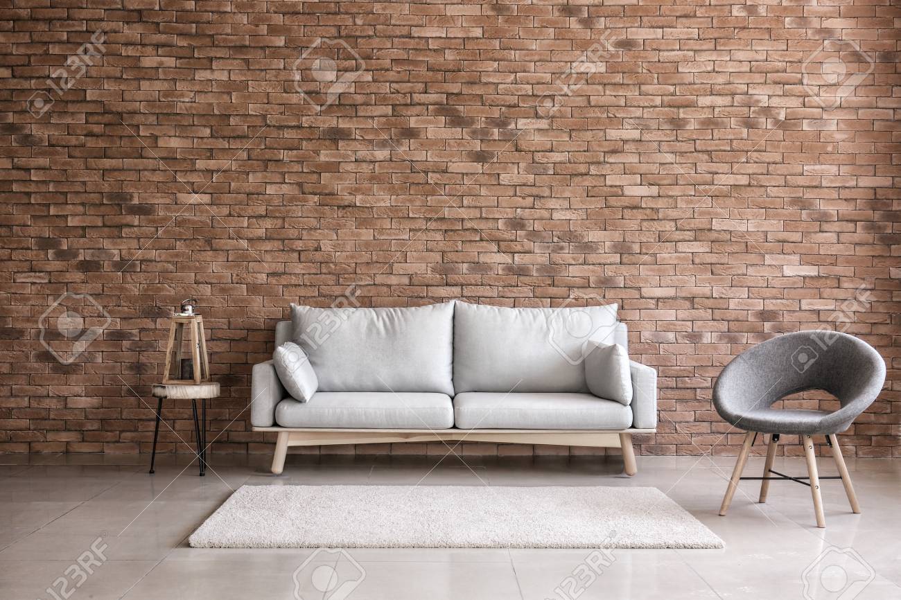 Modern interior of living room with comfortable sofa and armchair near brick wall - 113861359 Modern interior of living room with comfortable sofa and armchair near brick wall - 113861359