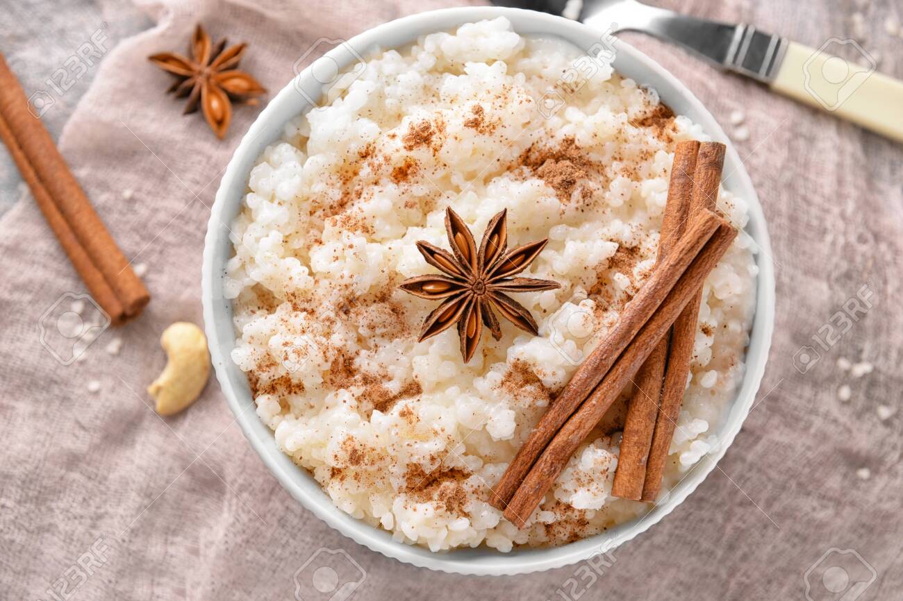 Bowl with tasty rice pudding, cinnamon and anise on gauze cloth - 115051098 Bowl with tasty rice pudding, cinnamon and anise on gauze cloth - 115051098