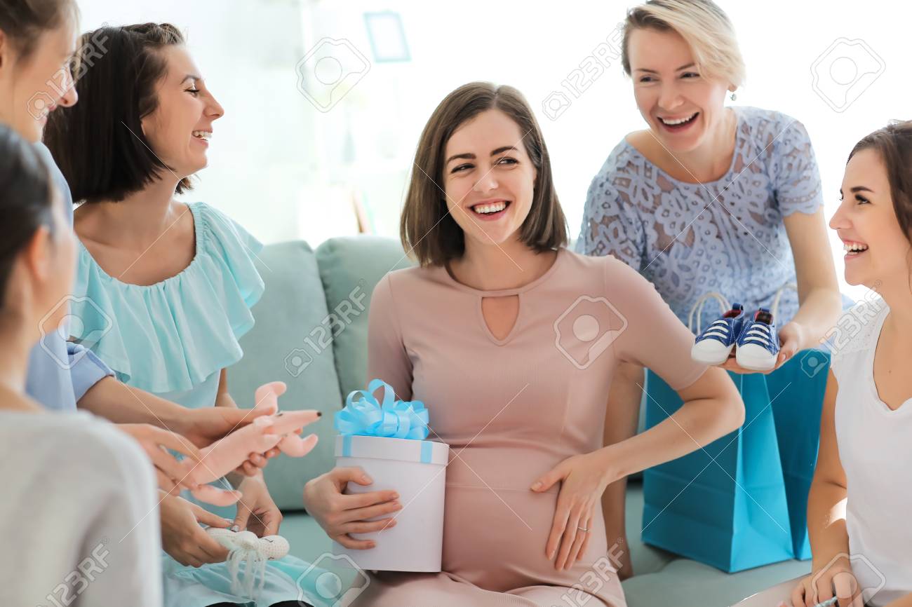 Pregnant woman with her friends at baby shower party - 115308422 Pregnant woman with her friends at baby shower party - 115308422