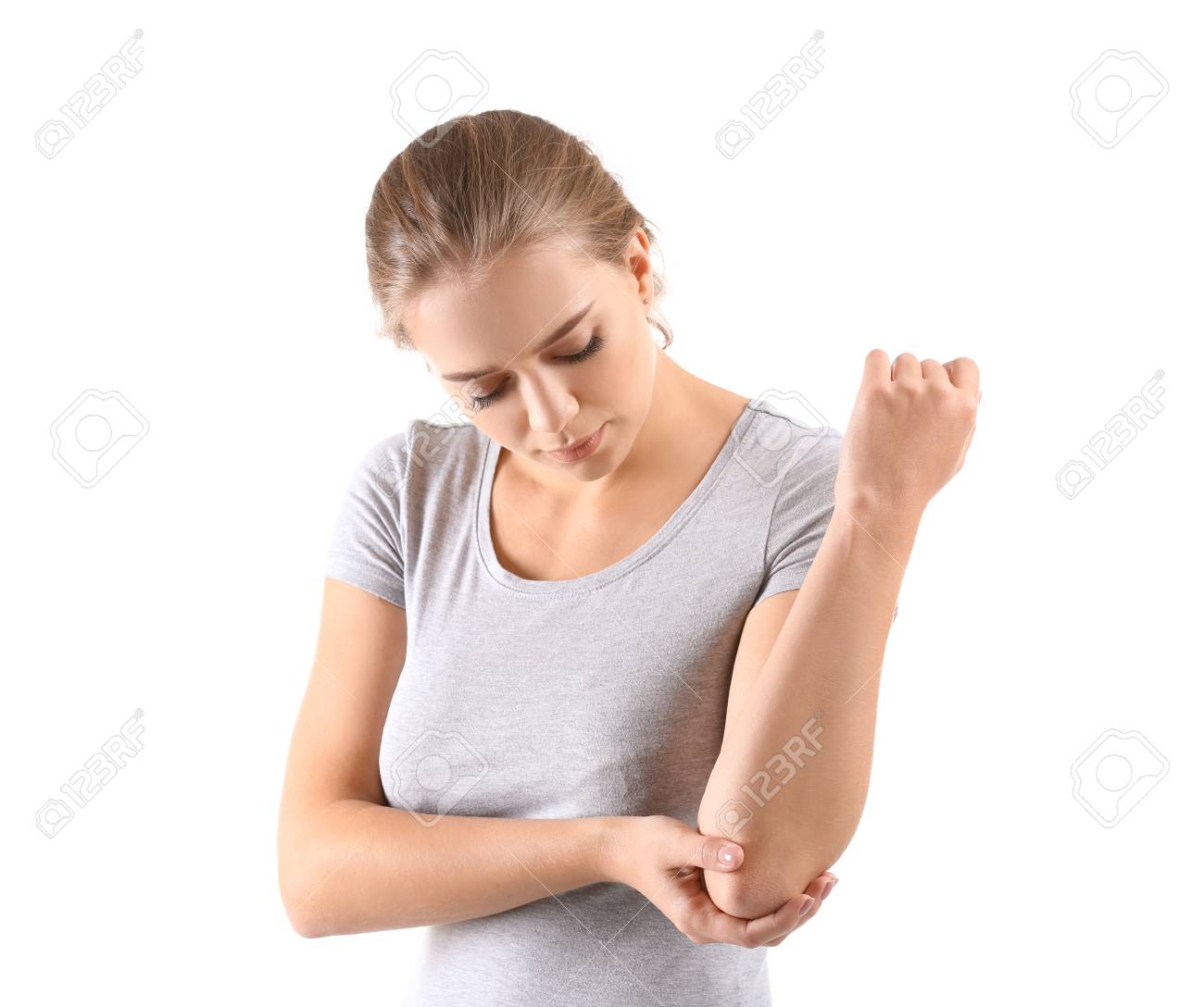 Young woman suffering from pain in elbow on white background - 115740418 Young woman suffering from pain in elbow on white background - 115740418