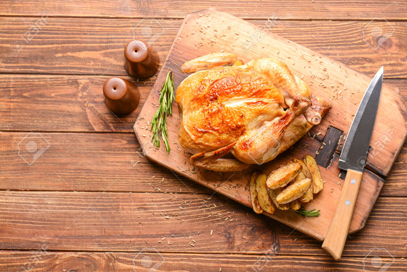 Board with baked chicken and potato on wooden table - 165734271 Board with baked chicken and potato on wooden table - 165734271