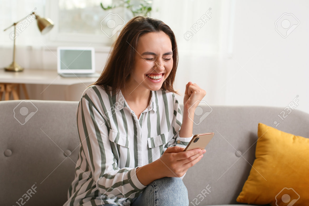 Menina asiática jogando emocionalmente no smartphone em jogo