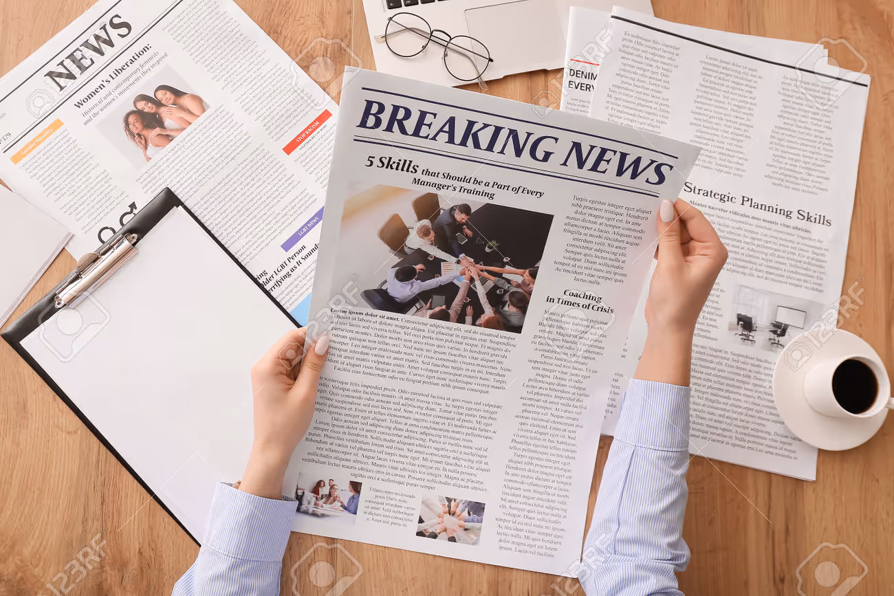 Young woman reading newspaper at table - 195892515 Young woman reading newspaper at table - 195892515