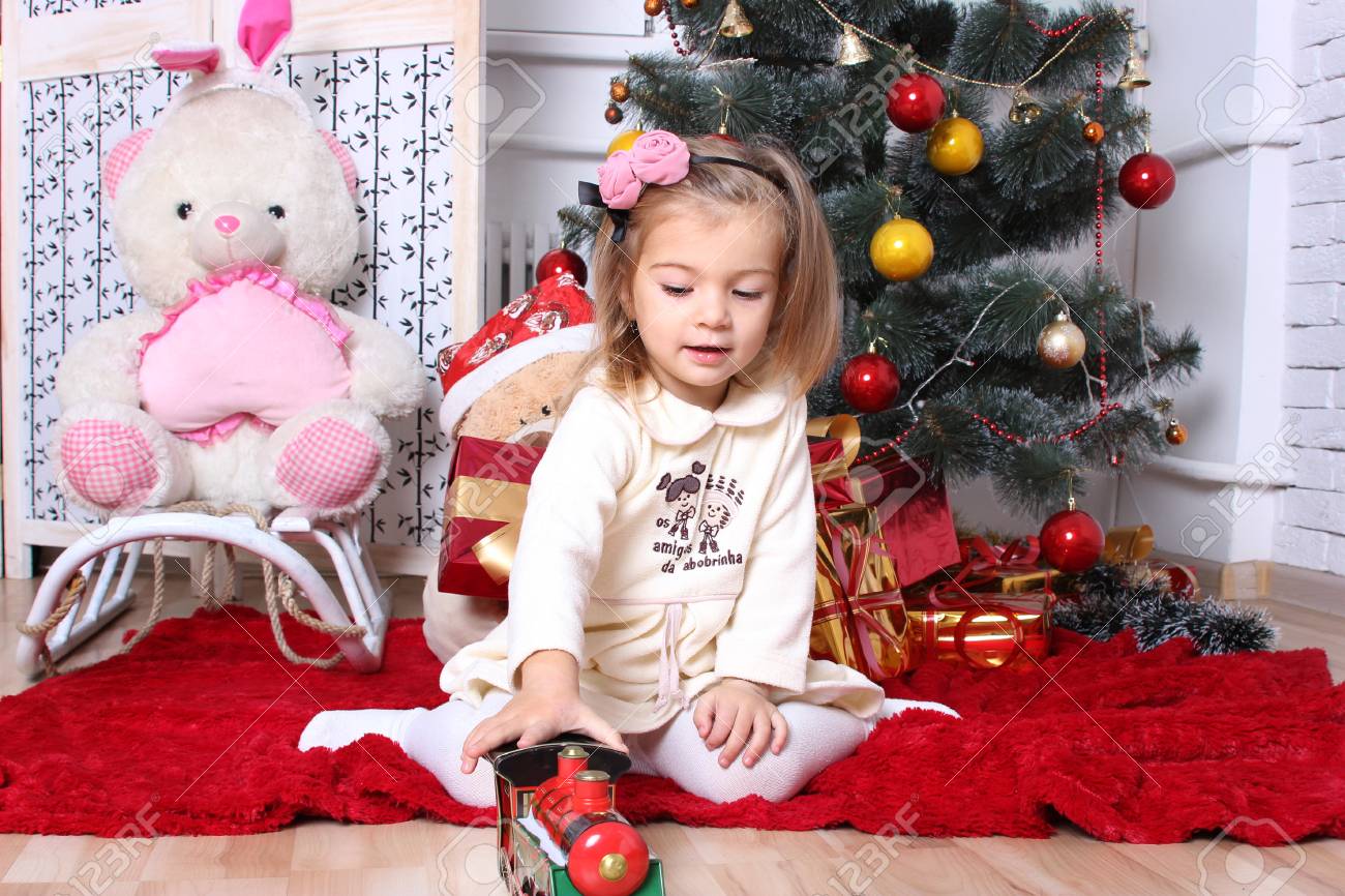 女の子おもちゃのエンジンとクリスマスのモミの木下ギフト の写真素材 画像素材 Image