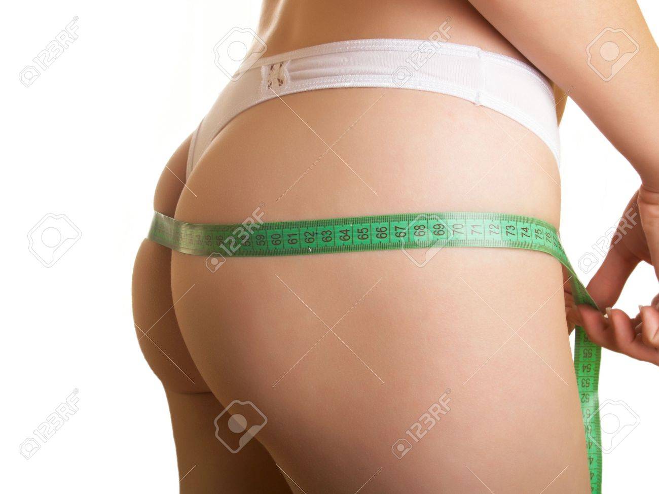 Stock Photo The Young Woman Measures To Itself A Ass On A White Background Stock Photo The Young Woman Measures To Itself A Ass On A White Background
