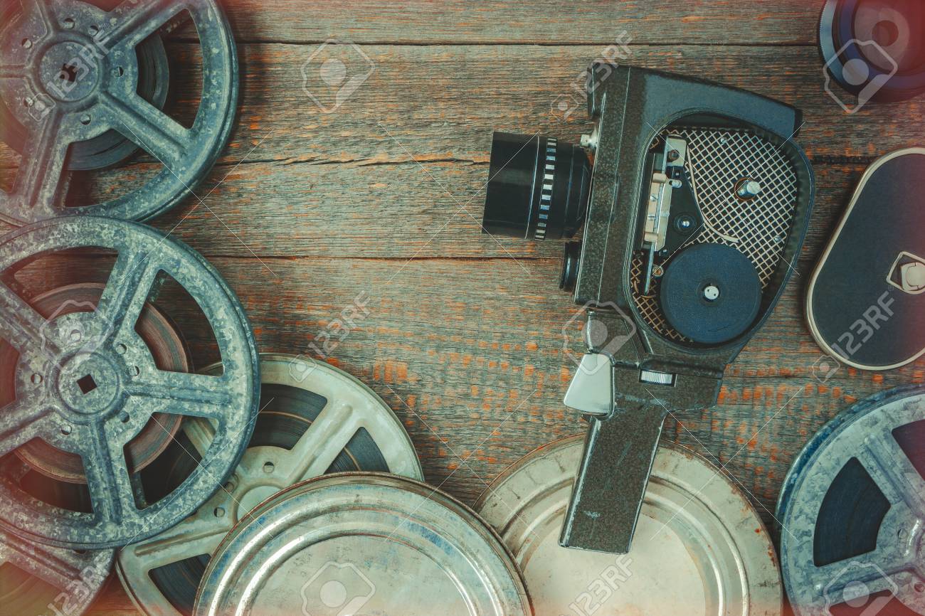 Old Movie Camera And Film Reel Lying On A Wooden Table.Film Effect From The  Illuminated Edges Stock Photo, Picture and Royalty Free Image. Image  69456551., image size:1300x866