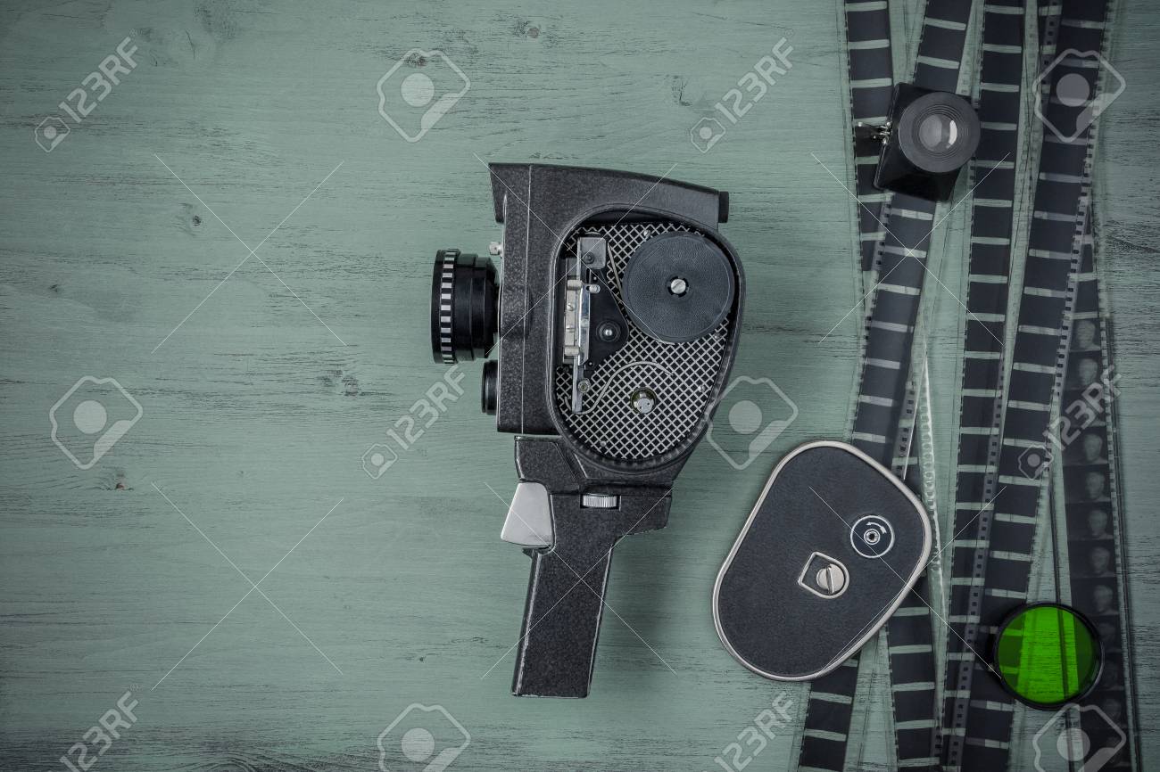 old movie camera film and filter are on the painted table stock
