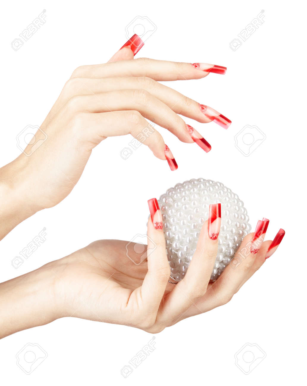 Hands with red french false acrylic nails manicure holding perl..