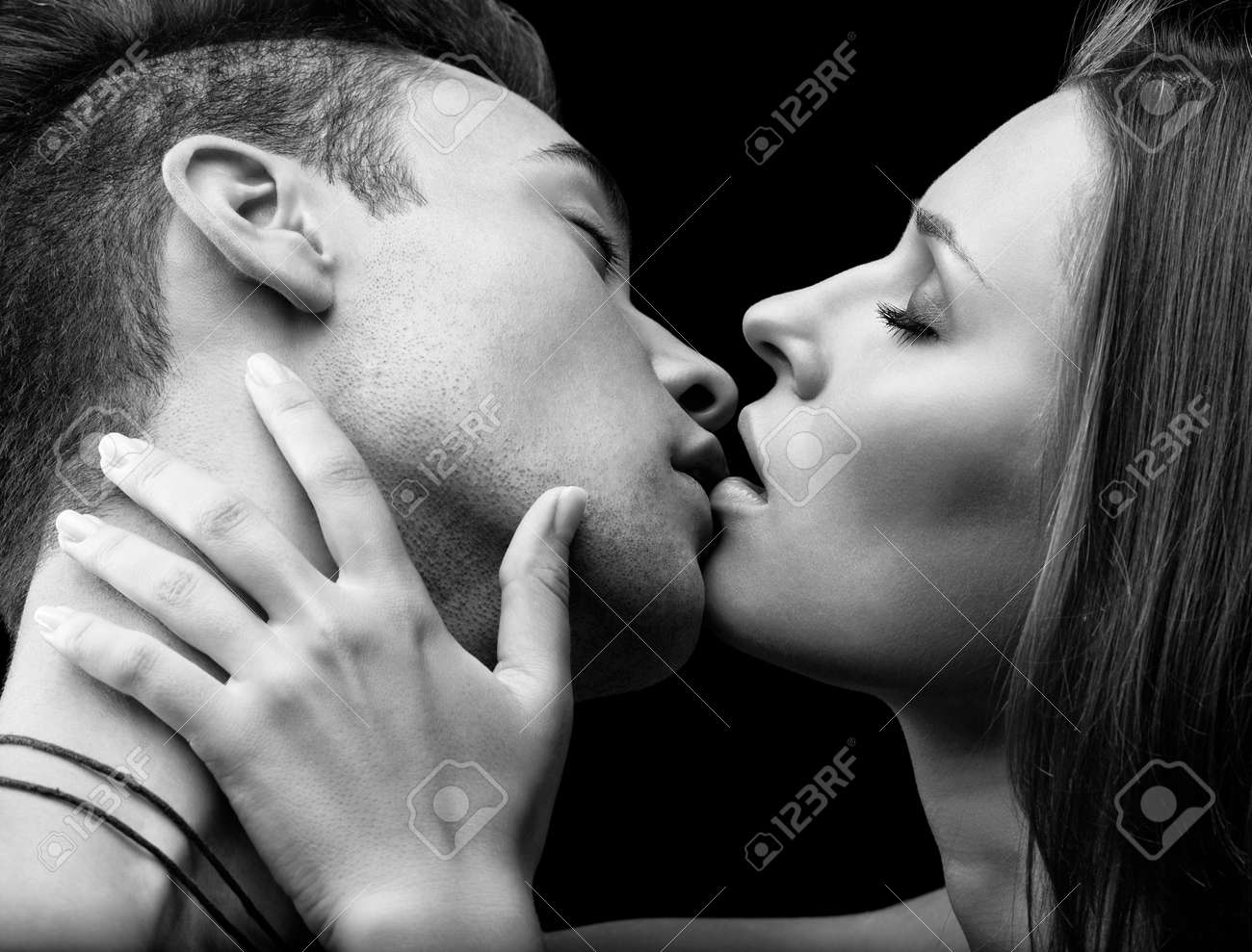Stock photo young couple of lovers kissing on black background