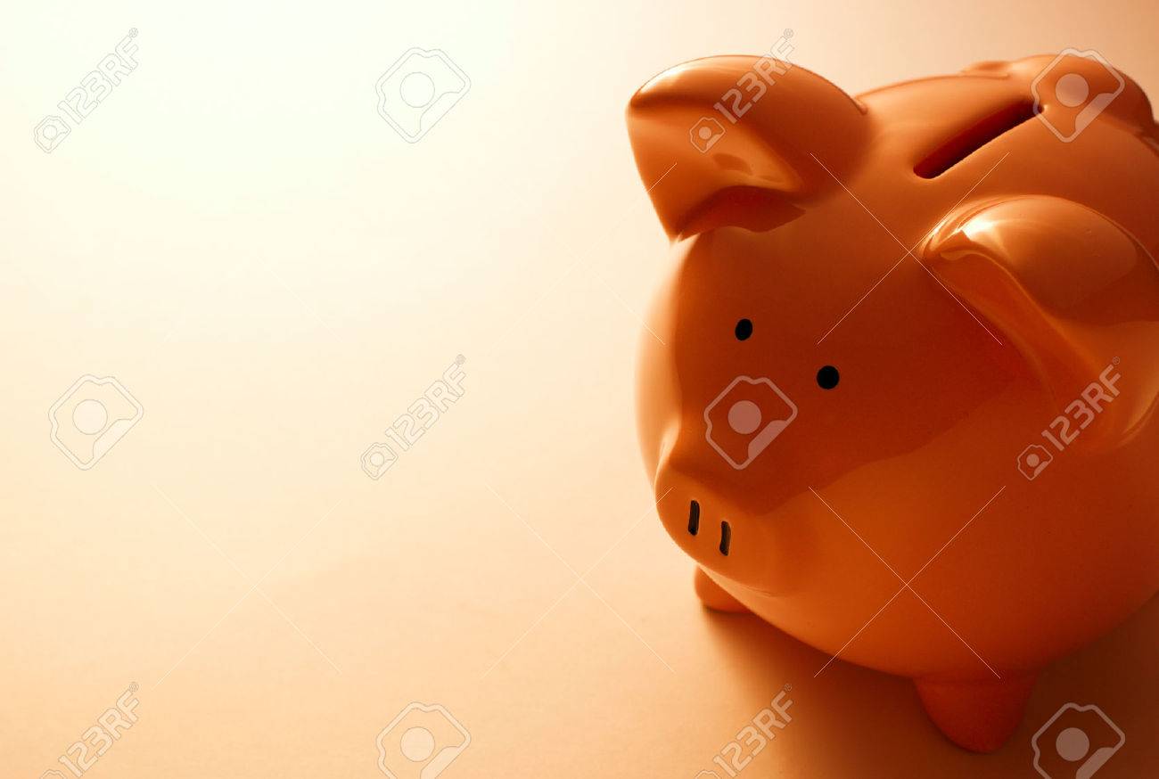Backlit pink ceramic piggy bank standing facing the camera in a financial, savings and investment concept - 30977210 Backlit pink ceramic piggy bank standing facing the camera in a financial, savings and investment concept - 30977210