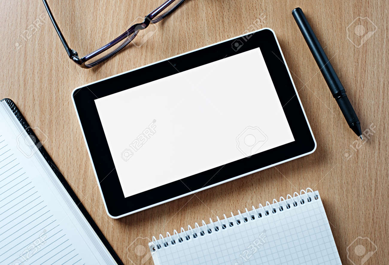 黒とコピー スペース ノート ペンや眼鏡に囲まれて木製のテーブル上の Whitetablet のコンピューターを閉じます の写真素材 画像素材 Image