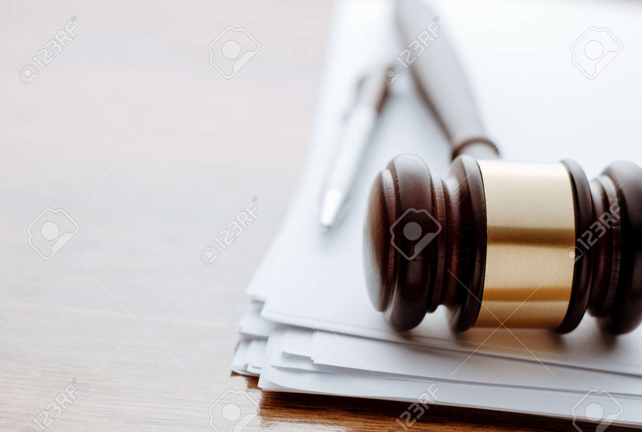 Gavel, ball pen and paper for notes lie on the wooden desk. - 34865044 Gavel, ball pen and paper for notes lie on the wooden desk. - 34865044