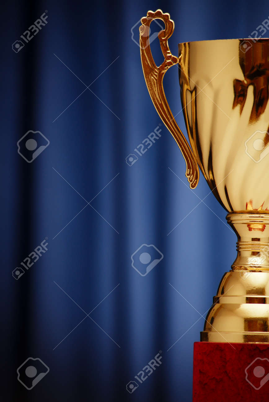 Golden glowing trophy cup on a dark blue background - 36510564 Golden glowing trophy cup on a dark blue background - 36510564