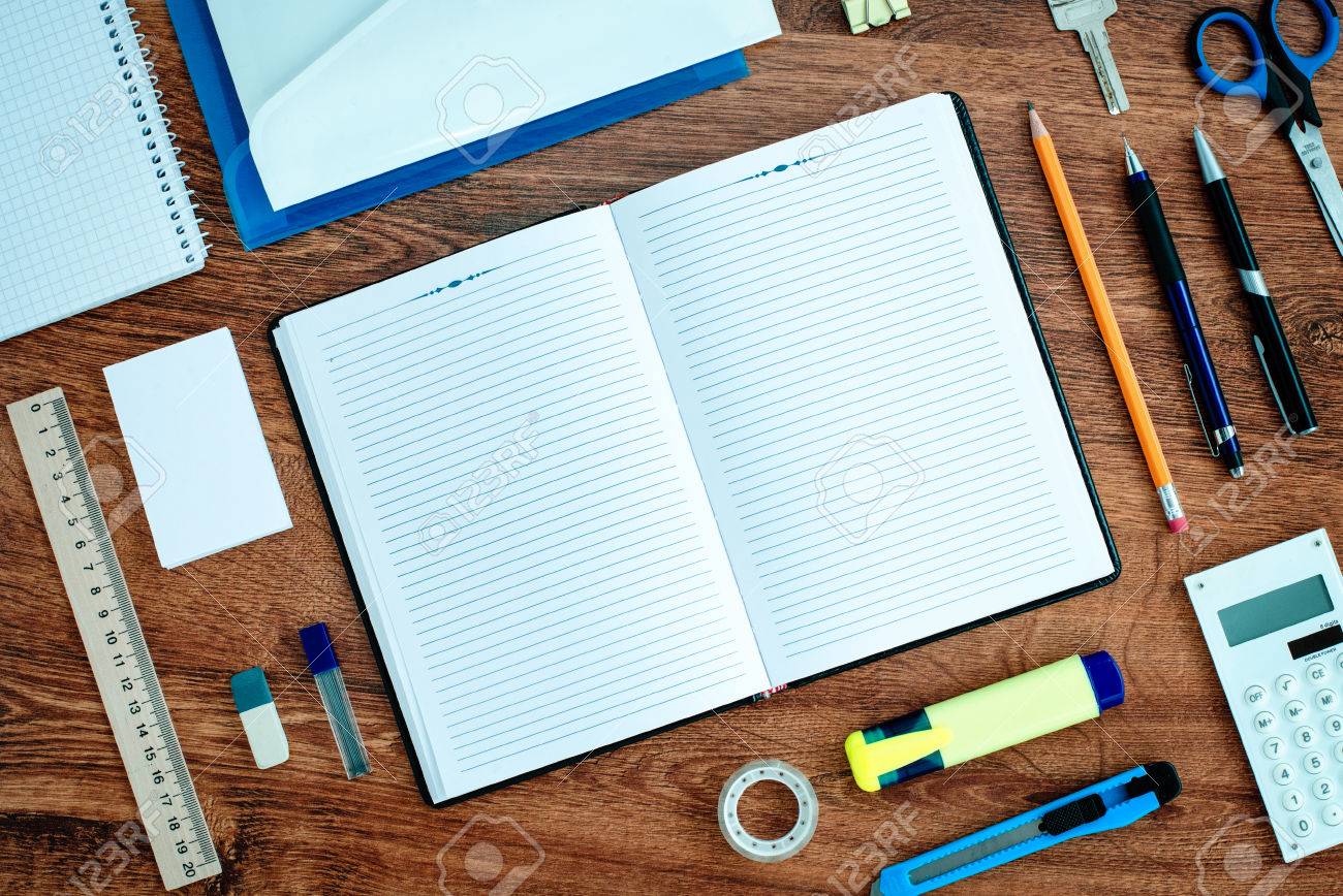 High Angle View of Office or School Supplies Neatly Organized Around Open Note Book with Blank Page on Wooden Desk Top - 40628491 High Angle View of Office or School Supplies Neatly Organized Around Open Note Book with Blank Page on Wooden Desk Top - 40628491