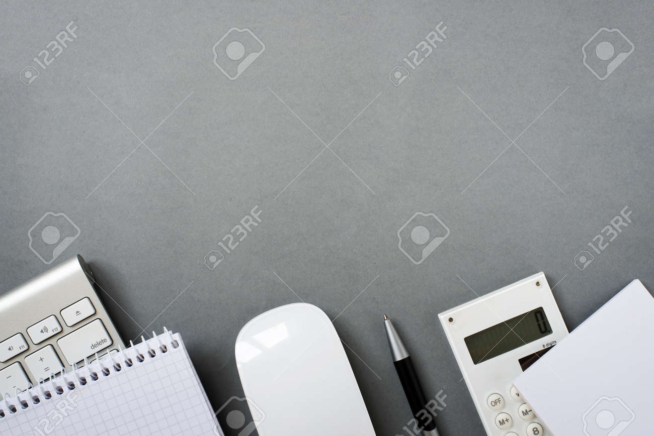 High Angle View of Mac Computer Keyboard and Mouse with Note Pads, Calculator and Pen on Grey Desk with Ample Copy Space - 40628500 High Angle View of Mac Computer Keyboard and Mouse with Note Pads, Calculator and Pen on Grey Desk with Ample Copy Space - 40628500