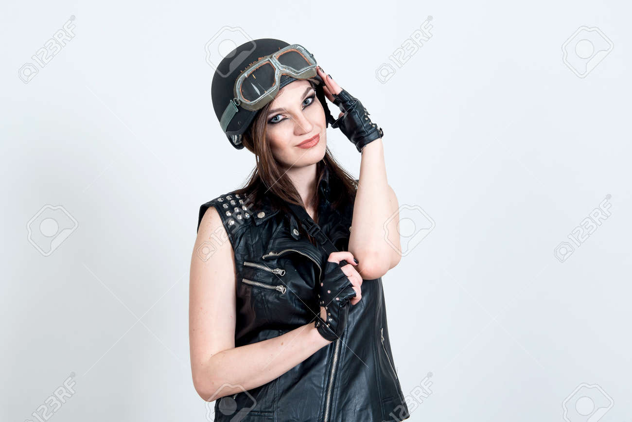 ファッションのセクシーな見事な流行に敏感な女性のポートレート 明るいビンテージ サングラス バイカー レザー ジャケット トレンディなジュエリーを作る Accessorizes 都市壁の背景 写真撮影は バイカーを緩和 の写真素材 画像素材 Image