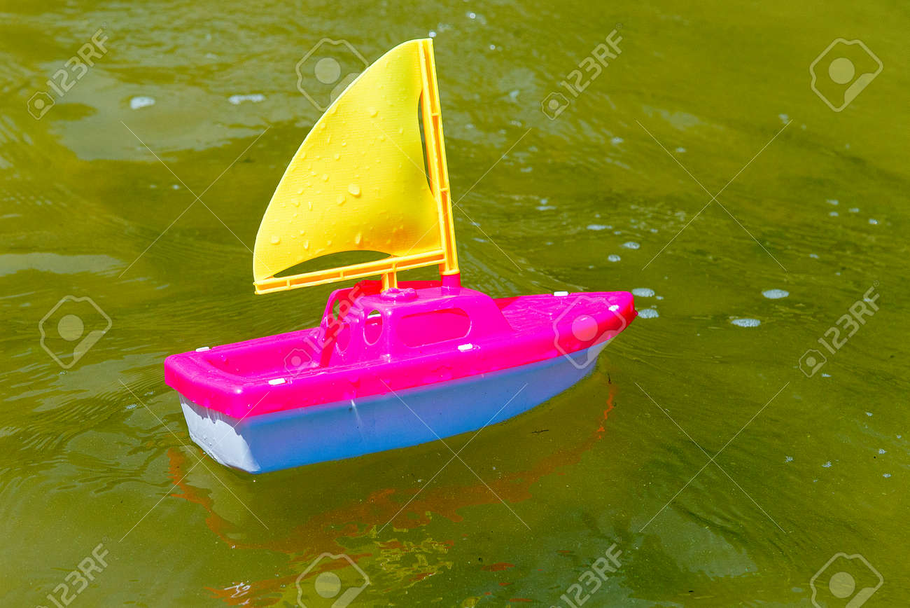 toy boat in the wet sand of the sea summer holidays at sea stock