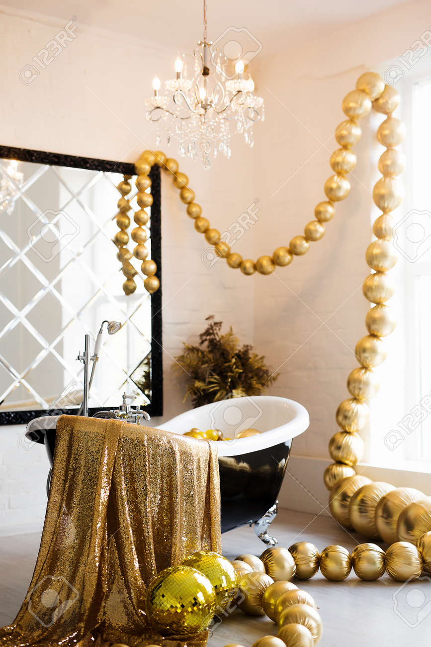 Vintage bright bathroom with black bath and mirror decorated with festive golden balls. Luxury bathroom interior. - 158318105 Vintage bright bathroom with black bath and mirror decorated with festive golden balls. Luxury bathroom interior. - 158318105