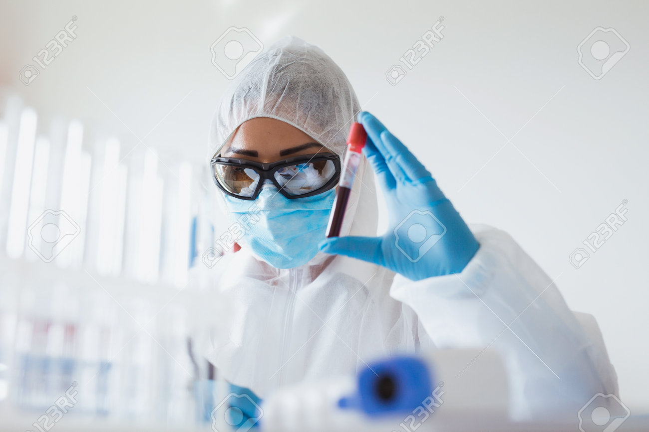 Coronavirus analysis concept. Medical worker holding blood sample in the laboratory with test for Covid-19. - 160650299 Coronavirus analysis concept. Medical worker holding blood sample in the laboratory with test for Covid-19. - 160650299