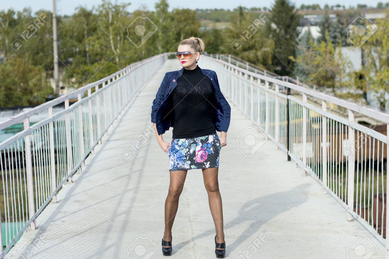 鉄道駅 件名の橋の真ん中にミニスカートの女性の美しい女性と線路 の写真素材 画像素材 Image