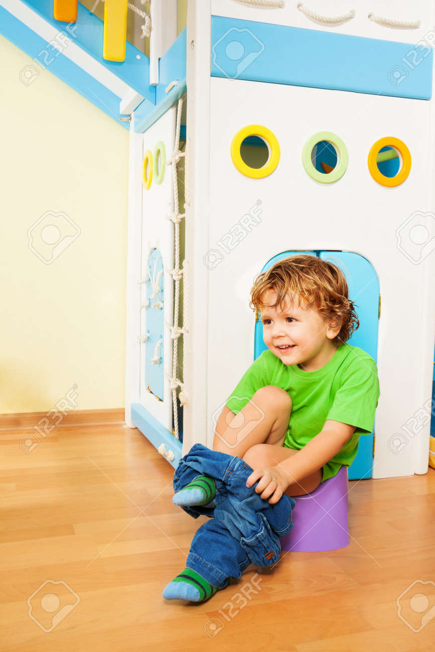 Small Two Years Old Boy Putting Off His Pants As He Learns To Use