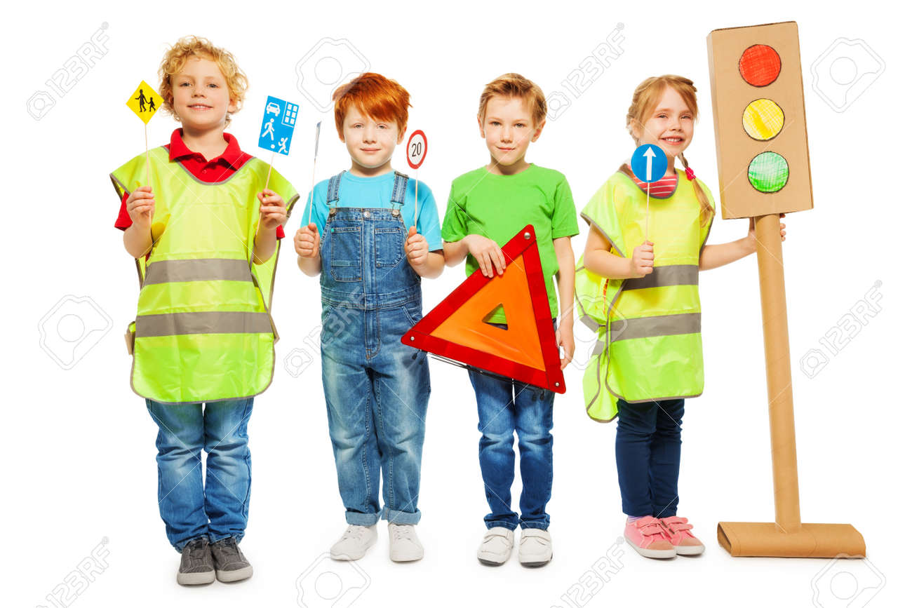 Four kids in high visibility jackets standing in a row, holding warning triangle, road signs and light-signal models, isolated on white - 62152410 Four kids in high visibility jackets standing in a row, holding warning triangle, road signs and light-signal models, isolated on white - 62152410