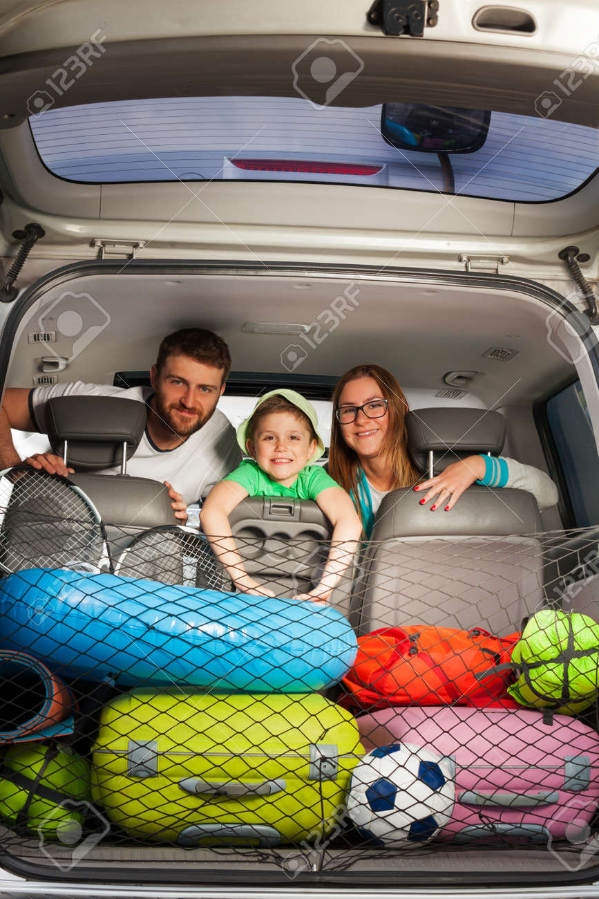 幸せな家族 若い親 車の座席に座っている子供男の子は完全な荷物の起動から表示します の写真素材 画像素材 Image