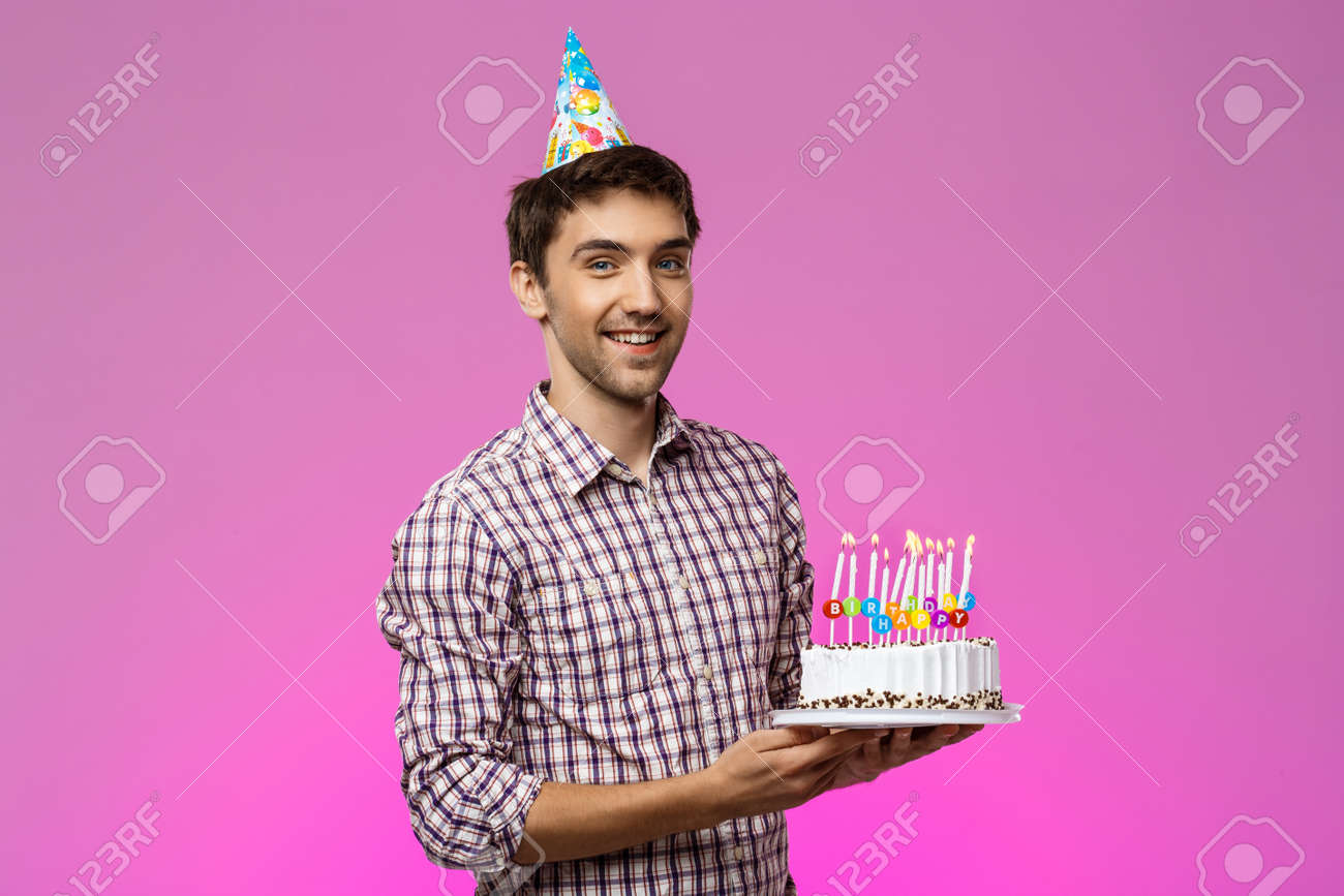 Jeune Homme Beau Souriant Tenant Un Gateau D Anniversaire Sur Fond Violet Espace De Copie Banque D Images Et Photos Libres De Droits Image