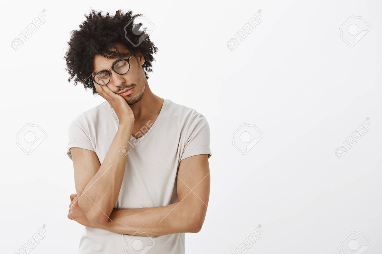Indoor Shot Of Cute Sleepy Male Hispanic Model With Curly Hair