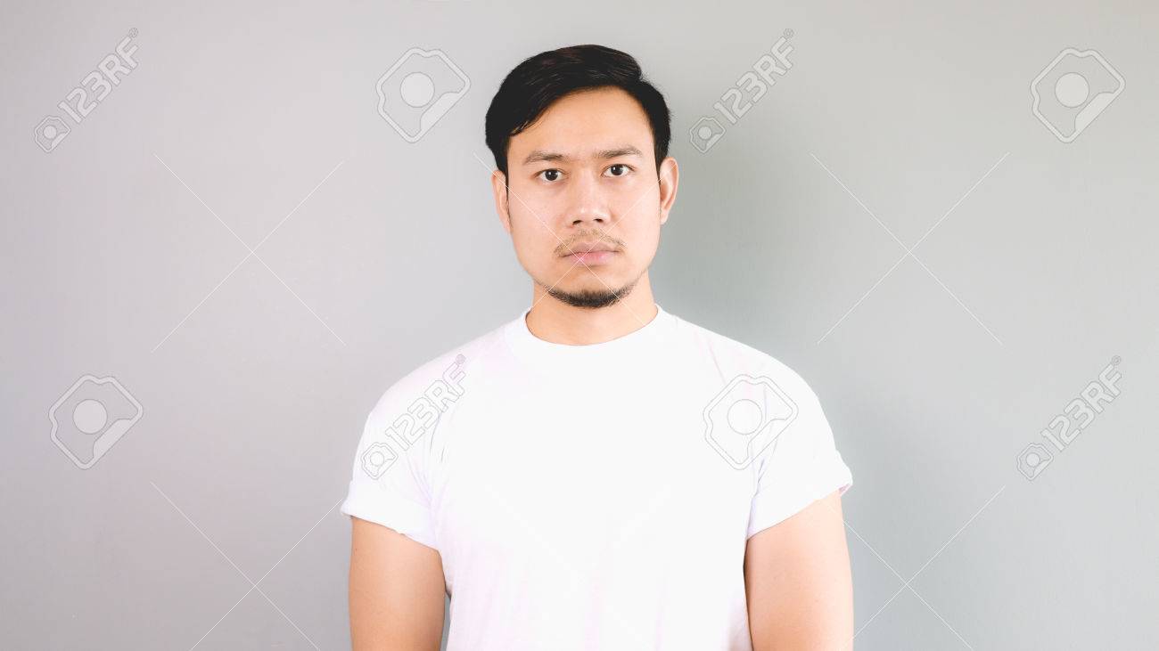 まじめな顔 白い T シャツとグレーの背景を持つアジア人 の写真素材 画像素材 Image