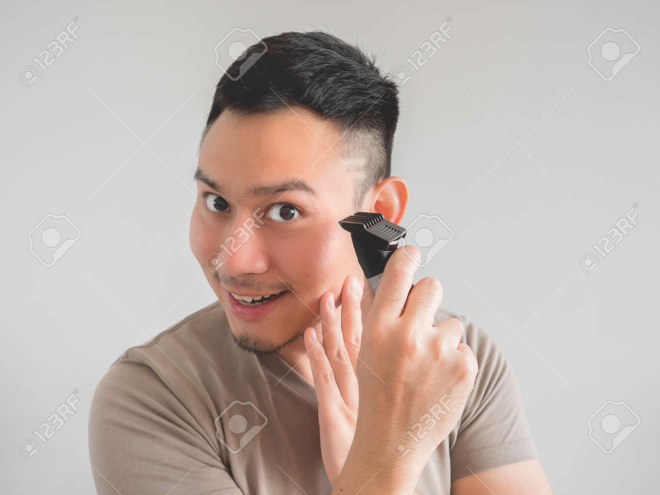 アジア人男性は クリッパーやシザーと自分の髪を切る の写真素材 画像素材 Image