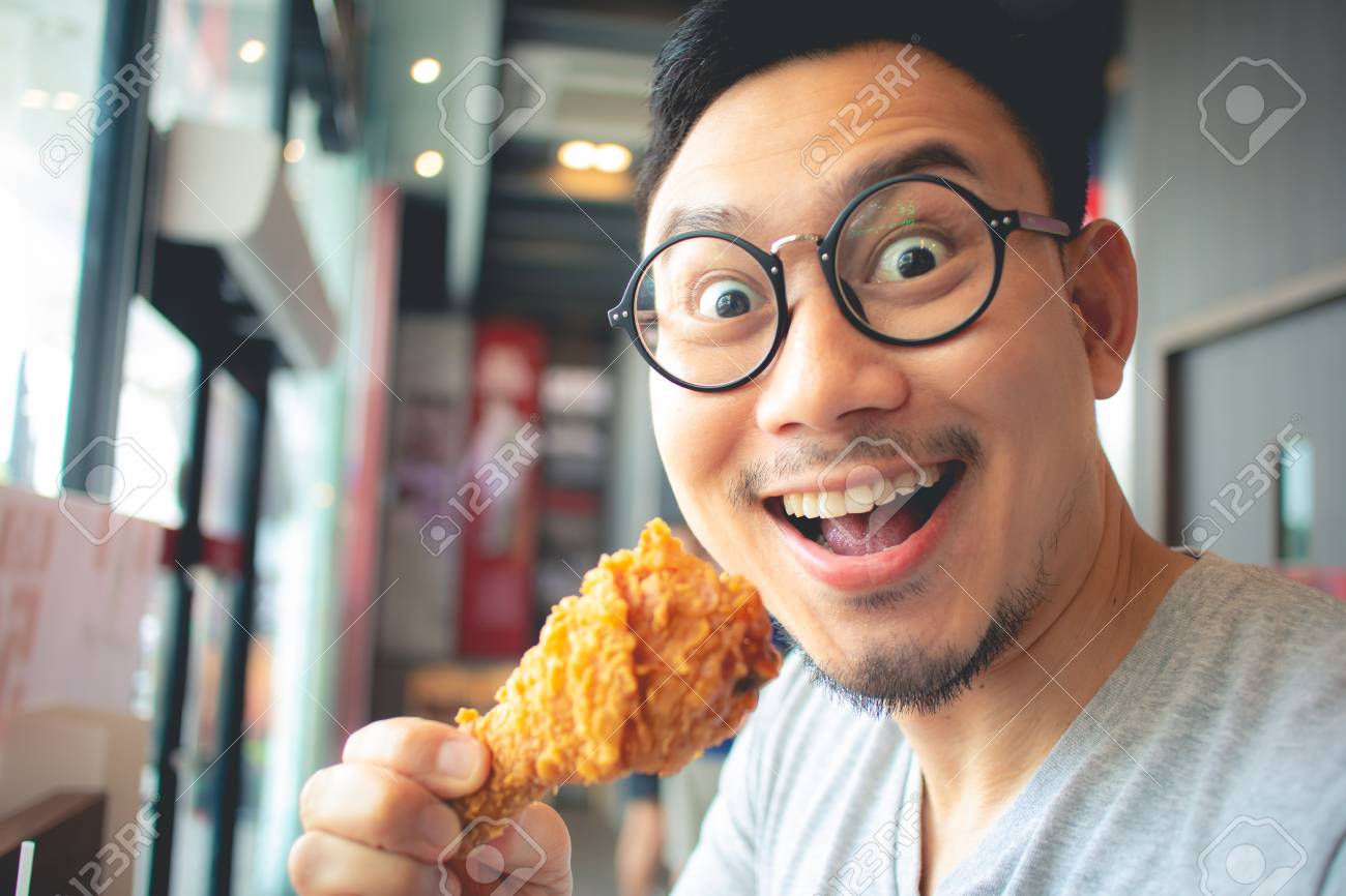 Funny Face Of Asian Man Eat Fried Chicken In The Franchise Cafe. Stock  Photo, Picture and Royalty Free Image. Image 119489133., image size:1300x866