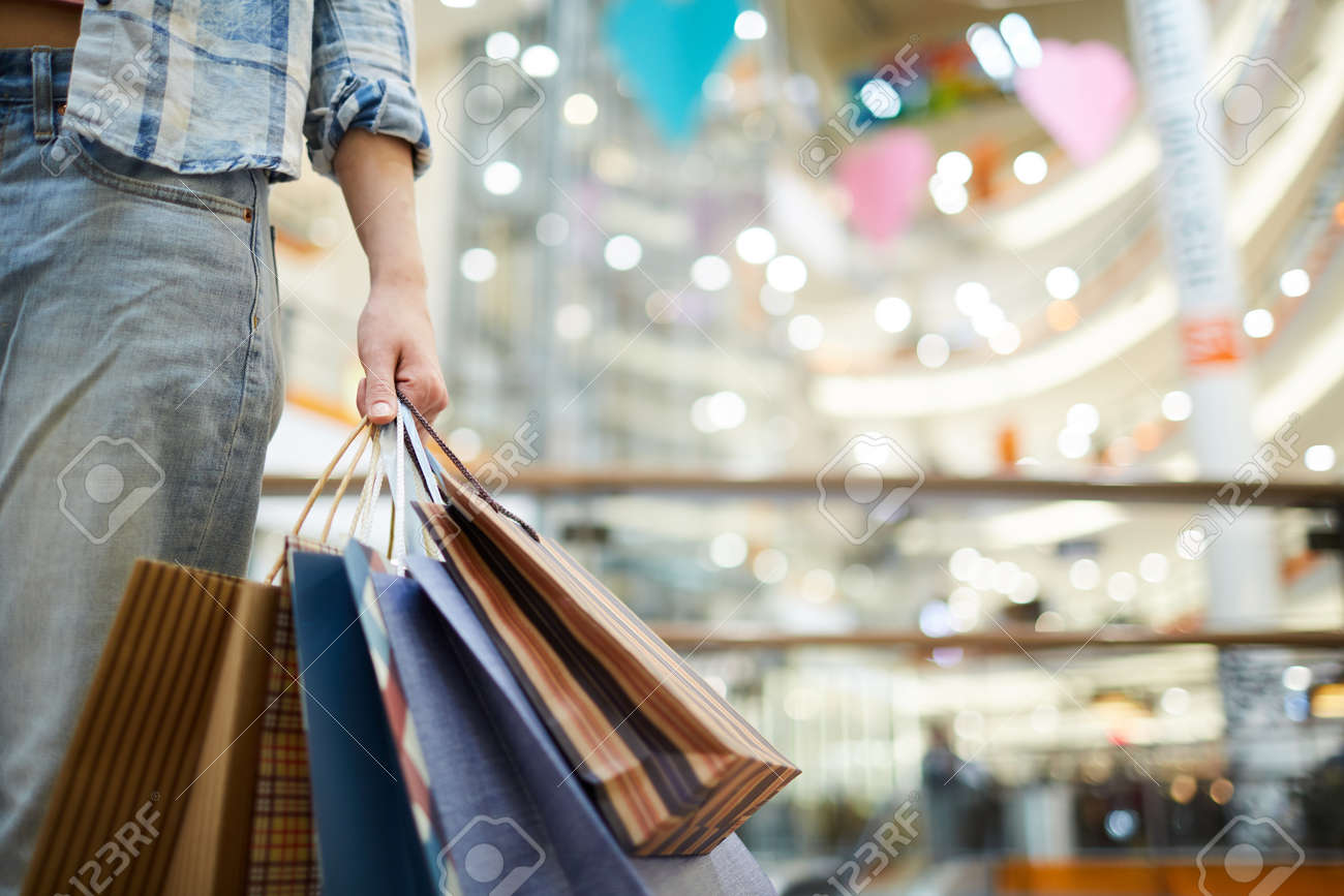 Carrying shopping bags in mall - 119630703 Carrying shopping bags in mall - 119630703